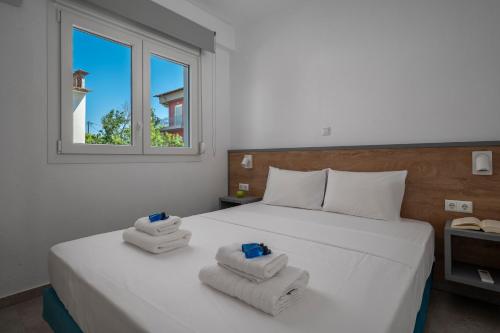 a bedroom with a white bed with towels on it at SLV Danai 7 Apartments in Ofrínion