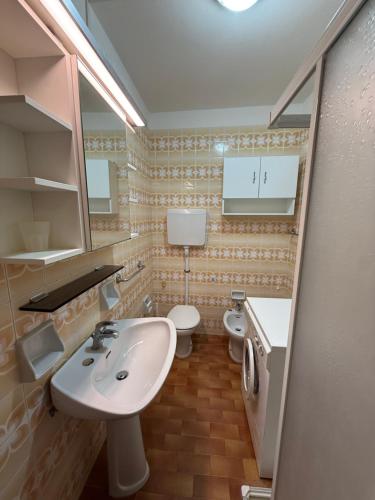 a bathroom with a sink and two toilets at Residence Luna in Lignano Sabbiadoro