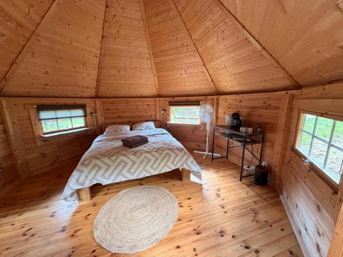 a bedroom with a bed in a wooden cabin at Les cabanes de Condé in Condé-sur-Vesgre