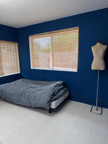 a blue bedroom with a bed and two windows at MIYARA GARDEN House in Ishigaki Island