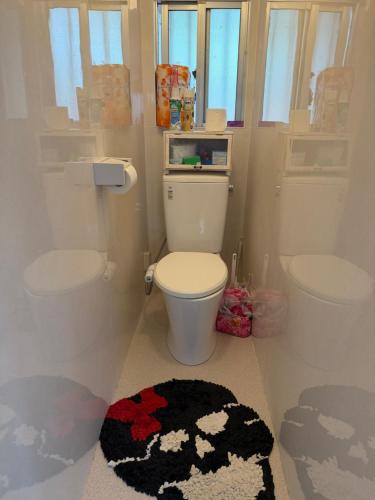 a bathroom with a toilet and a black and white rug at MIYARA GARDEN House in Ishigaki Island