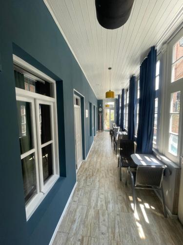 a hallway with blue walls and tables and windows at Hostel Room 110 in Tbilisi City