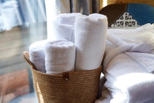 a basket filled with towels on top of a bed at Kokhta Cottage Kazbegi 2 in Kazbegi