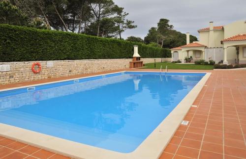 a large blue swimming pool in a yard at D. Duarte Townhouse in Casal da Lagoa Seca