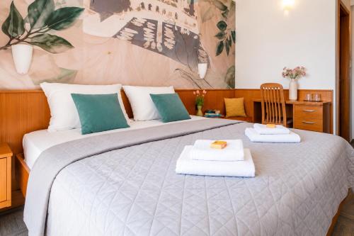a bedroom with a large bed with towels on it at Hotel Kastil in Bol