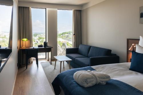 ein Schlafzimmer mit Bett, Sofa und Schreibtisch in der Unterkunft Quality Hotel The Book in Göteborg