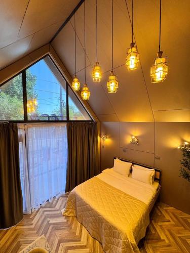 a bedroom with a bed in a room with a large window at ИксаОтель in Shymkent