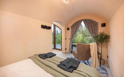 a bedroom with a bed and a chair and a window at Riverberg puhkemaja Otepääl in Otepää