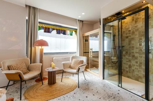 a bathroom with two chairs and a shower at Suite romantique Ibiza, Jacuzzi, Spa in Strasbourg
