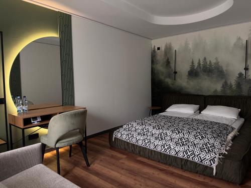 a bedroom with a bed and a desk and a chair at Котедж Gudz in Yaremche