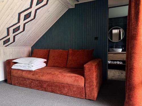 a red couch in a room with a green wall at Котедж Gudz in Yaremche