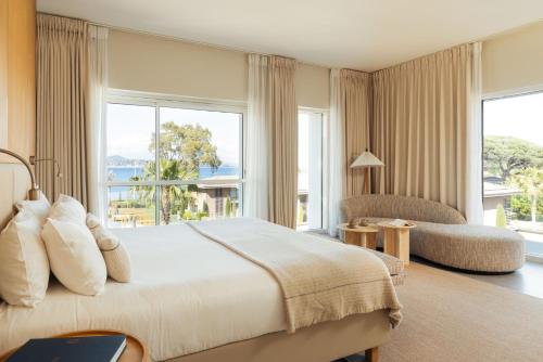a bedroom with a large bed and a large window at Kube Saint-Tropez in Saint-Tropez