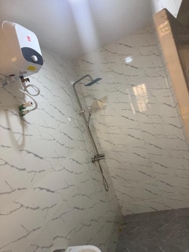 a shower in a bathroom with a white wall at Pristine Residences Premium 2 Bedroom Apartment Ajah Lagos in Lekki