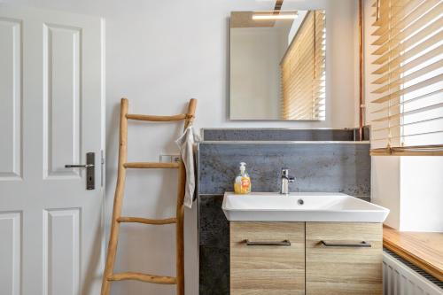 a bathroom with a sink and a mirror at Ferienwohnung auf Dreiseithof in Twedt