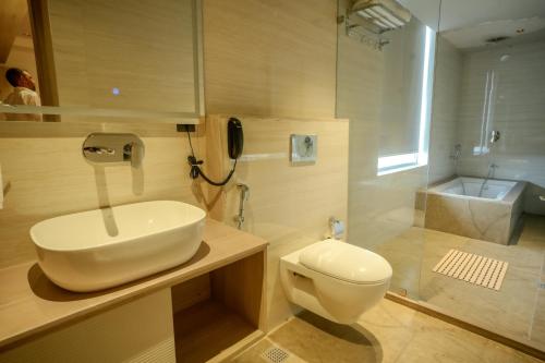 a bathroom with a sink and a toilet and a phone at Barsana Hotel & Resorts in Jaipur