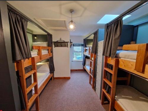 a room with four bunk beds and a room with a hallway at Glengarriff Hostel in Glengarriff