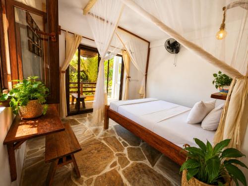 ein Schlafzimmer mit einem Bett und einem Tisch in der Unterkunft Beach Bohème in Paje