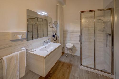 a white bathroom with a sink and a shower at Hotel Cortaccia Sanvitale in Sala Baganza