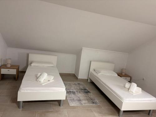 two beds in a room with white sheets and pillows at Apartment Ivan in Karlobag