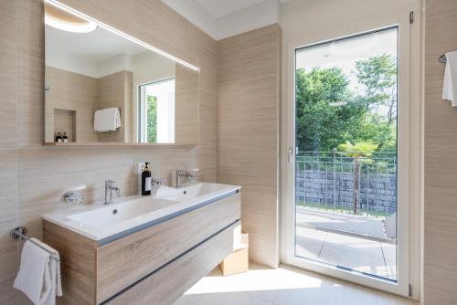a bathroom with a sink and a mirror at Appartement Rosalia Delta Resort 741 in Ascona