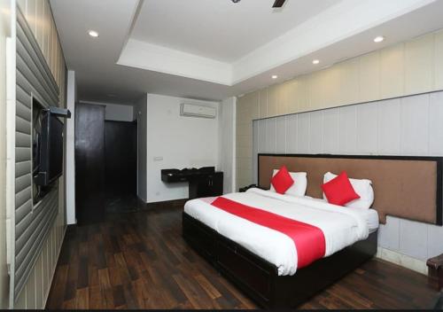 a bedroom with a large bed with red pillows at The Avenue Residency in Gurgaon