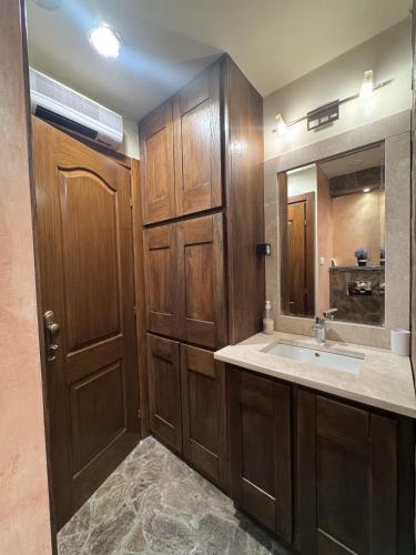 a bathroom with a sink and a wooden door at Apartman Trg in Šabac