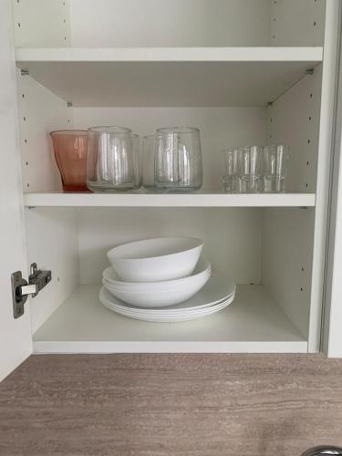 a white cabinet with plates and bowls and glasses at Your Home 27 with parking in Myslava
