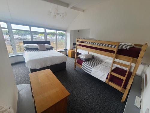 a room with two bunk beds and a table at Oakwood Airport Accommodation in Lulsgate Bottom