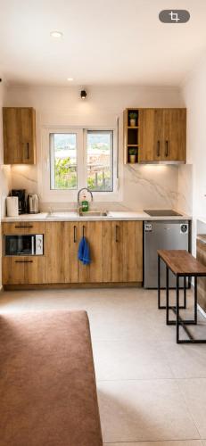 a large kitchen with wooden cabinets and a table at Panagiotis' Seaside Apartment, Giorgos`House in Gialova