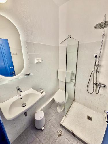 a bathroom with a toilet and a sink and a shower at Pelagos Studios in Parikia