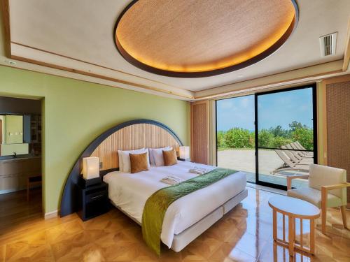 a bedroom with a large bed and a large window at Miyakojima Kurima Resort Seawood Hotel in Miyako-jima
