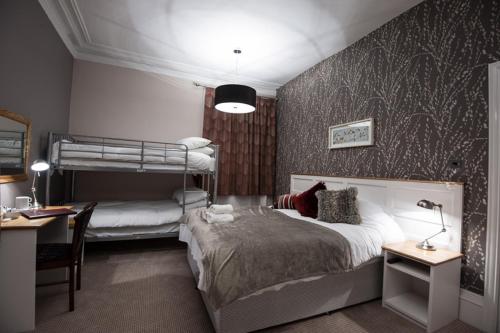 a bedroom with two bunk beds and a desk at Parkwood Hotel in Stockton-on-Tees