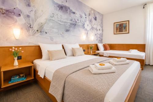 a hotel room with two beds with towels on them at Hotel Kastil in Bol