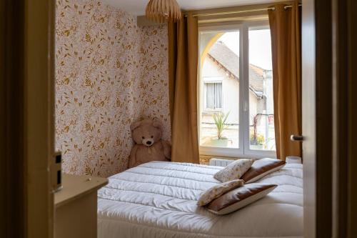 a bedroom with a bed with a window and a teddy bear at Maison AMARE 200 m de la plage in Berck-sur-Mer