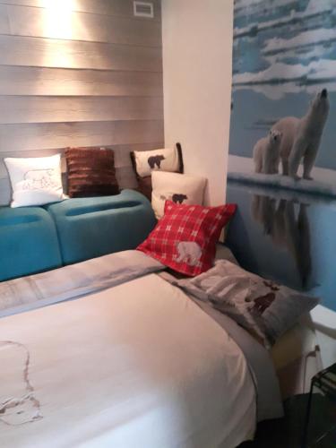 Cette chambre comprend un lit, un canapé et une peinture sur ours polaire. dans l'établissement Les Volets Bleus Alsace Vosges, à Urbès