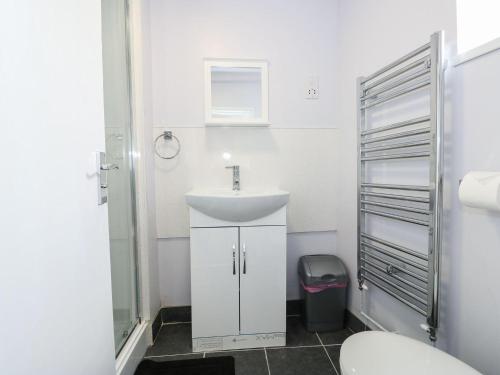a bathroom with a sink and a toilet at Oar Cottage in Mablethorpe