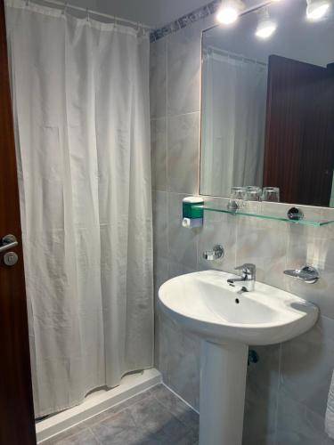 a bathroom with a sink and a shower curtain at Hotel Tanausu in Santa Cruz de Tenerife