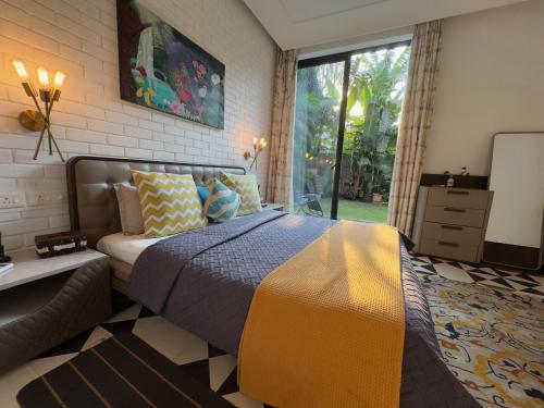a bedroom with a bed and a large window at Casa Mahua, Anjuna Vagator near Beach, with Pvt pool & Garden in Vagator