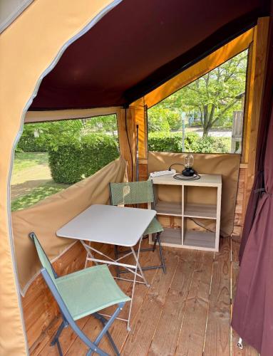 a table and two chairs and a table in a tent at Camping Onlycamp Pierre & Sources in Volvic