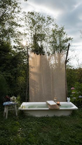 a bath tub sitting in the grass in a yard at Green bunny ArtHouse in Martvili
