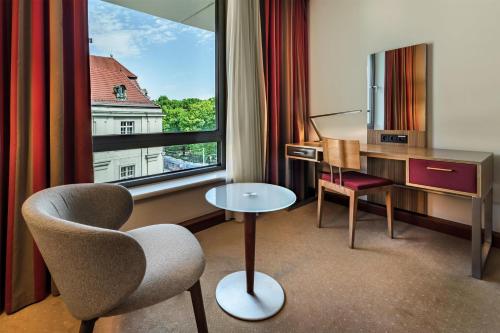a hotel room with a chair and a desk and a window at Radisson Blu Hotel Krakow in Krakow