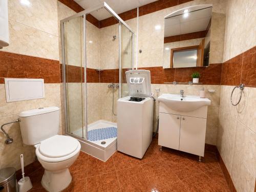 a bathroom with a toilet and a shower and a sink at Two-bedroom apartment with garden view in Sunny Beach