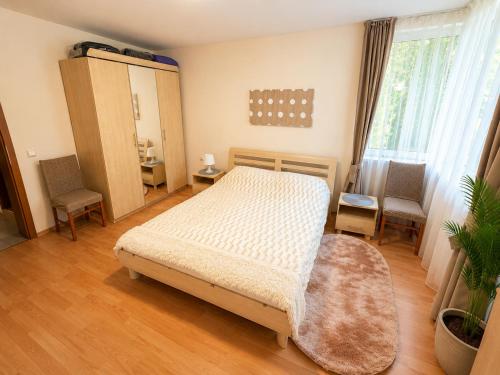 a bedroom with a bed and a table and chairs at Two-bedroom apartment with garden view in Sunny Beach