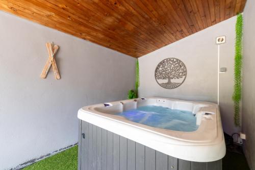 a jacuzzi tub in a room with a wooden ceiling at Grange des 2 Cols - Jacuzzi - Jardin in Campan