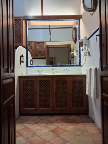 a bathroom with a large mirror and a sink at Hotel Ordóñez Sandoval in Úbeda