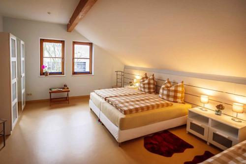 a bedroom with a large bed and two windows at Maisionette FEWO Sternchen in Heidenau