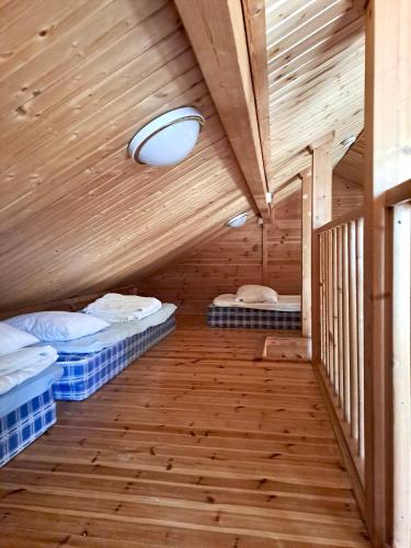 a room with two beds in a wooden cabin at Holiday Home Marina in Tahkovuori