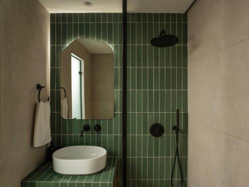 a green tiled bathroom with a sink and a mirror at Eudaimonia - Luxury Apartment in Agrinio in Agrinio