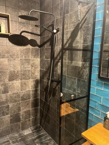 a bathroom with a shower with a glass door at Gastenverblijf Boven De S l a g e r i j in Schijndel