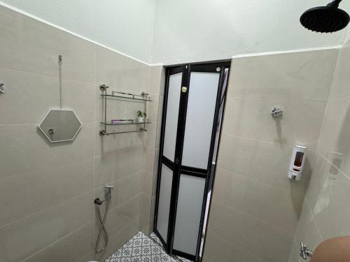 a shower with a glass door in a bathroom at Private Pool Homestay Kota Bharu 3 Bilik Tidur Muat 12 Tetamu in Kota Bharu
